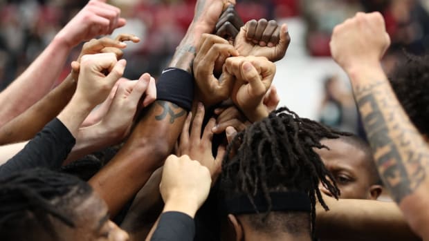 The Mizzou men's basketball team comes out of a huddle.